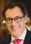 Un hombre con lentes y corbata sonriendo
Descripción generada automáticamente